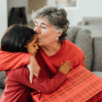 top 7 personalized gifts for grandparents grandma holding gift and kissing granddaughter on the forehead